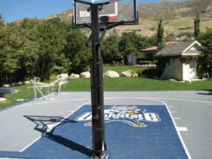 Residential outdoor basketball court with custom logo with mountains in the background