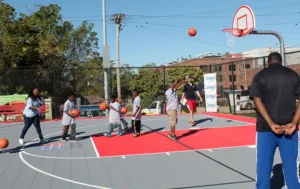 A group of eight people playing basketball on an outdoor court