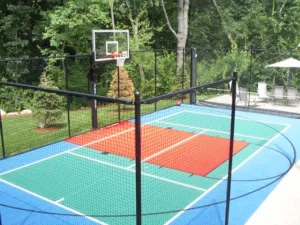 Outdoor game court with a basketball hoop next to a patio set