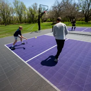 A family playing pickleball on an outdoor multi-sport court on a sunny day