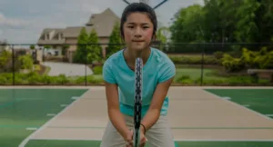 A young girl looking determined and ready to play tennis on a residential outdoor court