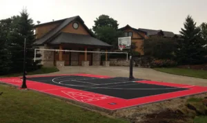 Multi-sport court in backyard setting with basketball hoop and volleyball net
