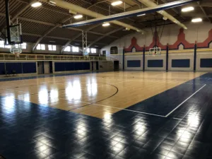 Indoor gymnasium with multiple ceiling mounted basketball hoops