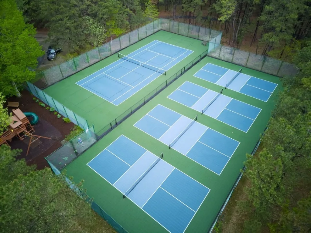 Residential pickleball courts installed in a wooded backyard
