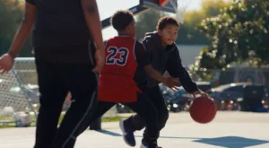 Two kids playing basketball on a Norther California court